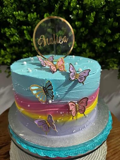 Bolo de aniversário com borboletas coloridas e degradê azul, rosa e amarelo